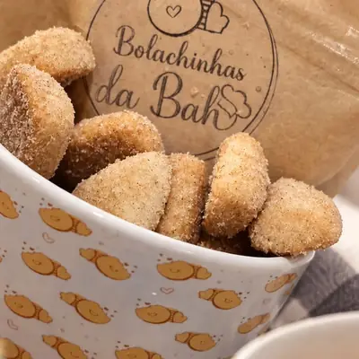 Caneca estampada com bolachinhas de açúcar e canela e o saquinho kraft com o carimbo da marca
