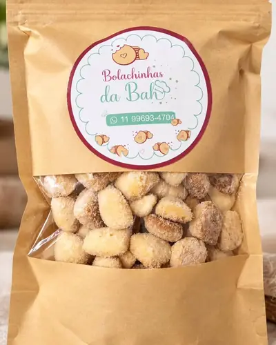 Pacotinho kraft com janela cheio de bolachinhas de açúcar e canela e a etiqueta da Bolachinhas da Bah